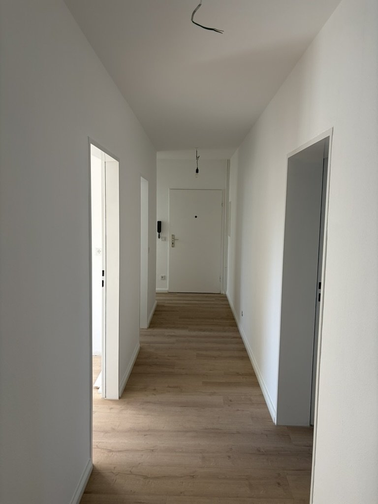 Frisch sanierte Wohnung, Flur mit neuem Bodenbelag und weiß gestrichenen Wänden